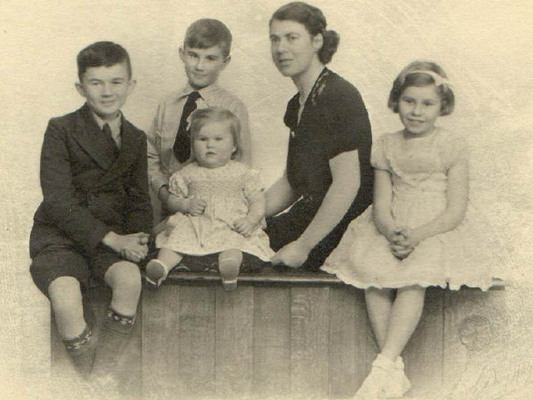 A vintage photo of a group of people posing for the camera
Description automatically generated